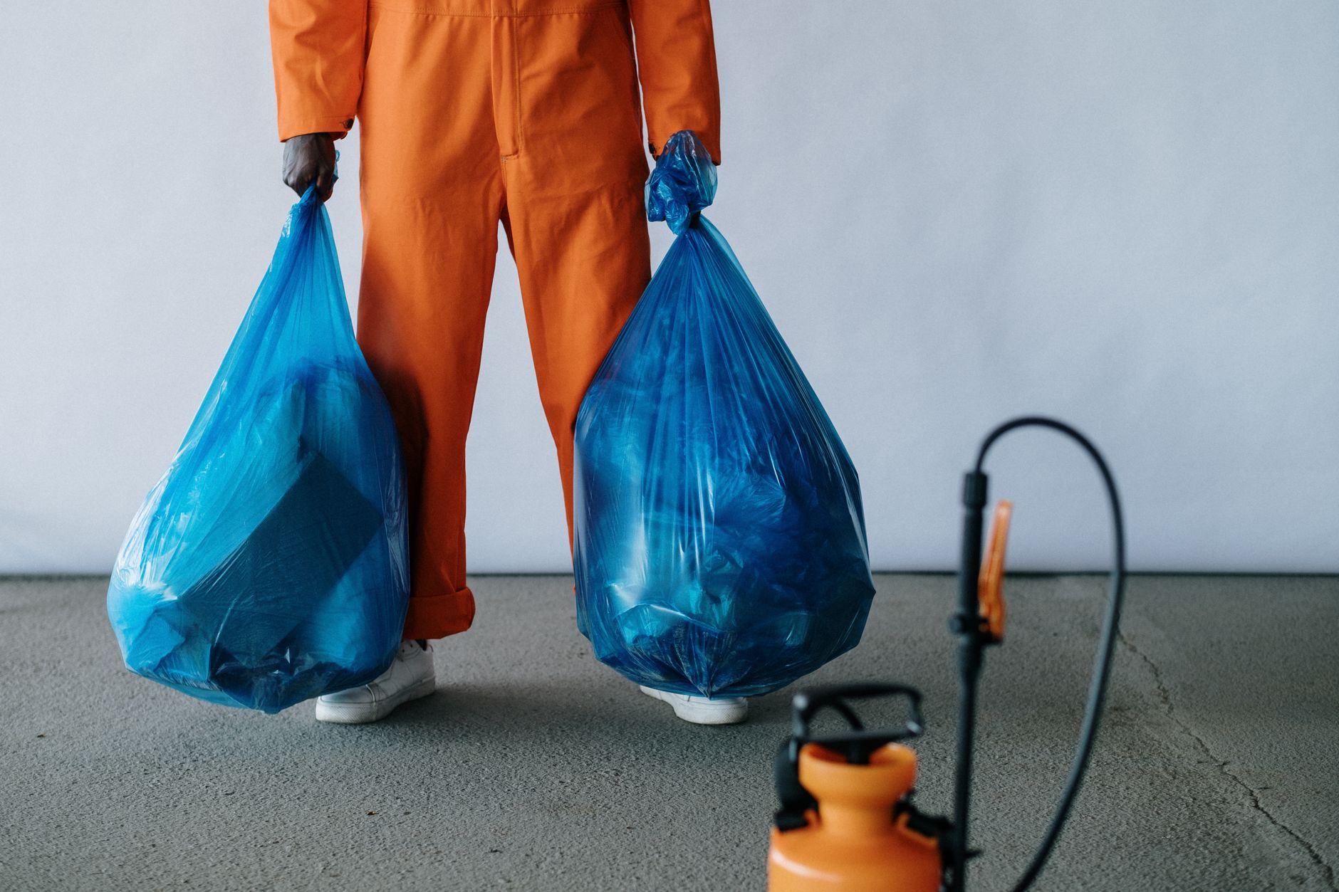 A close-up of a certified mold technician in Rowlett, Texas, wearing protective gear and carefully inspecting a hidden area for mold growth with specialized equipment.